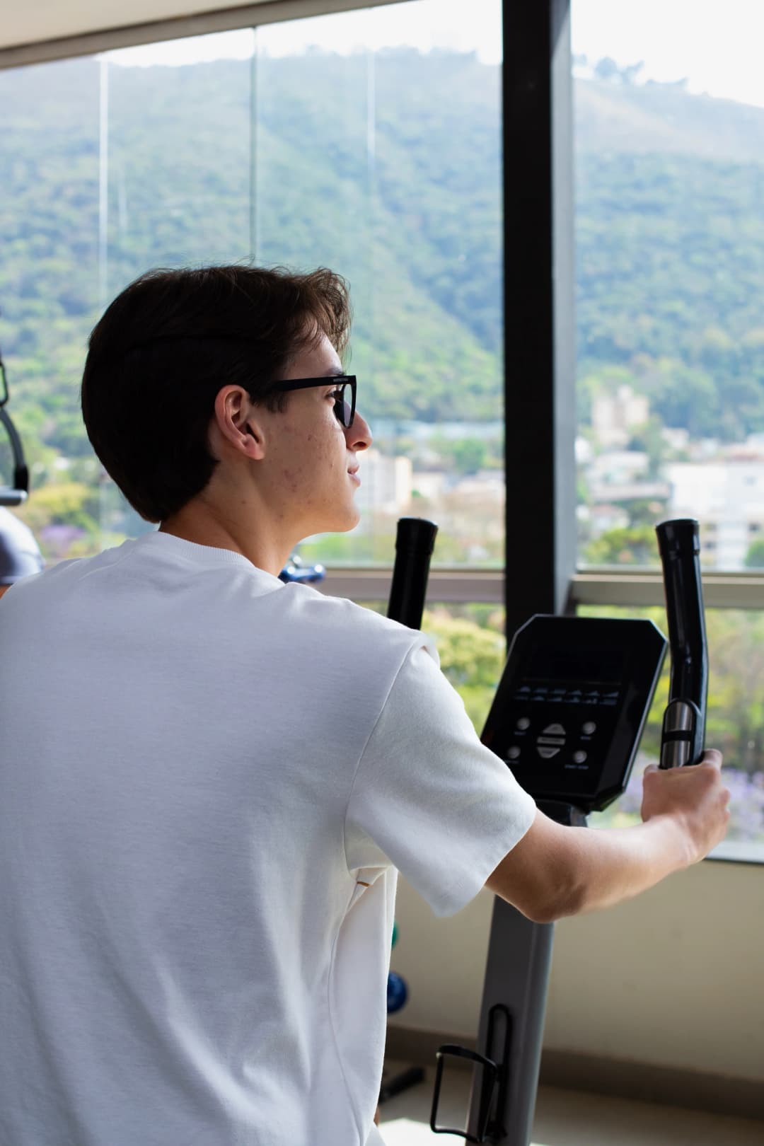 Painel de bicicleta ergométrica com vista panorâmica para a cidade e montanhas.